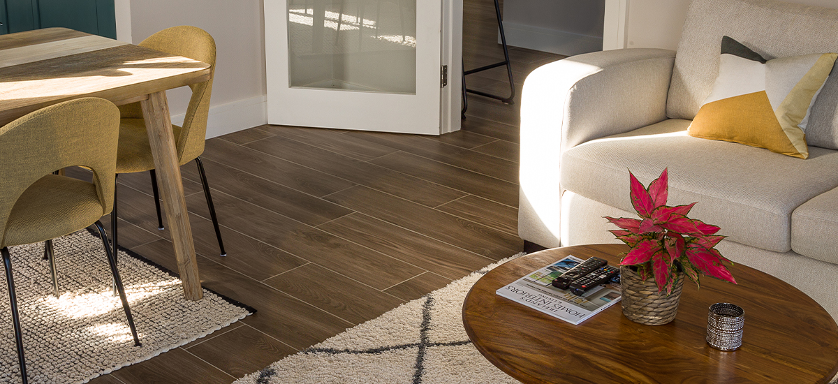 A modern Irish kitchen featuring light oak wood-effect porcelain floor tiles in a staggered plank pattern, showing the realistic wood grain and texture.
