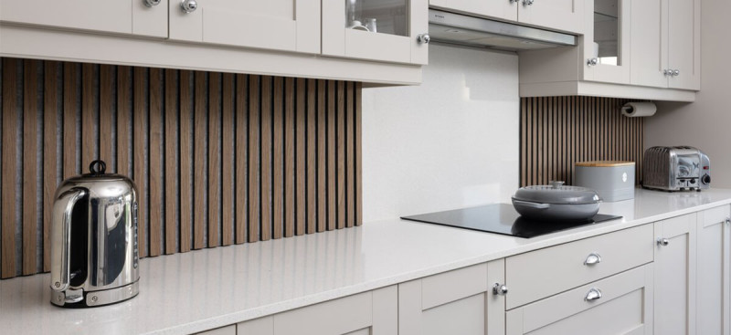 Modern kitchen featuring slatted wood wall panelling on a kitchen island and UV marble splashback panels, showcasing stylish and waterproof kitchen redecorating ideas.