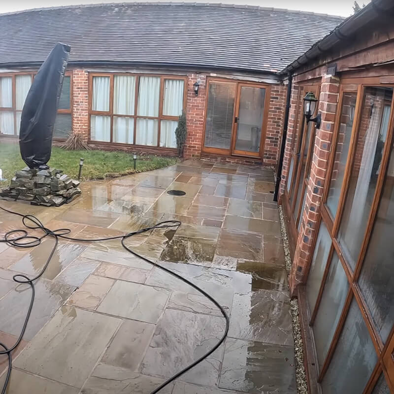 Outdoor patio with moss-covered concrete slabs. Here is the moment of cleaning,