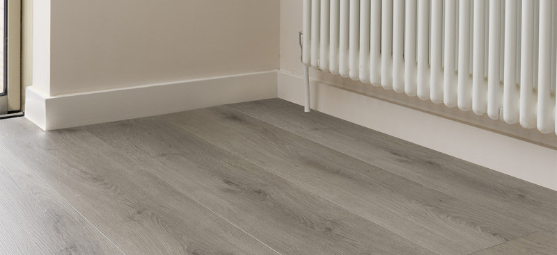 Detailed close-up of textured wood-effect flooring planks, showcasing the high-quality finish and durability of modern laminate and luxury vinyl.