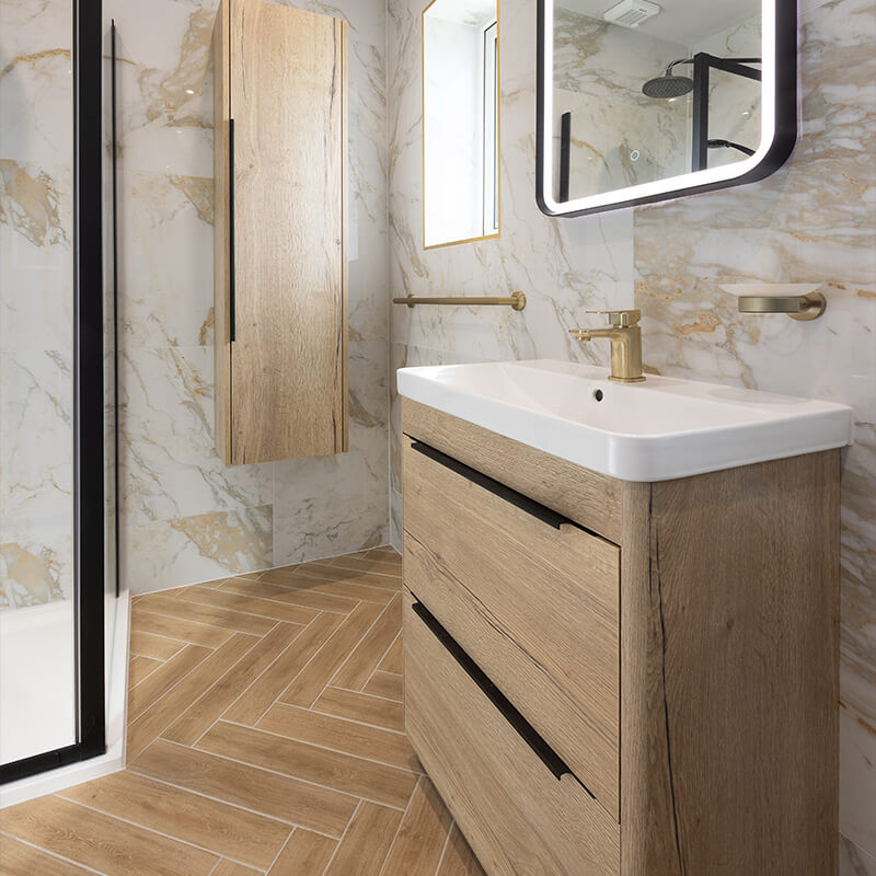 Small bathroom with wood-effect herringbone floor tiles, large marble-effect wall tiles and an oak vanity unit