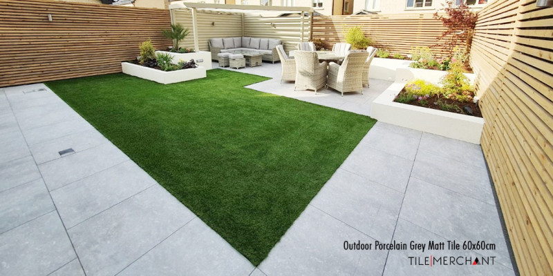 A comparison of grey outdoor porcelain tiles and natural limestone paving slabs in an Irish garden setting, highlighting the difference between modern and traditional patio styles.