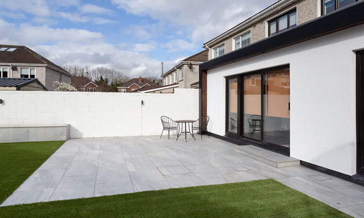 Removing black spot lichen from Indian Sandstone patio using Stontex Black Spot Remover, showing the restoration of natural stone pavers in an Irish garden.