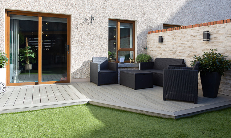 A step-by-step composite decking installation in an Irish garden, showing the hidden clip system being screwed into a pressure-treated timber frame.
