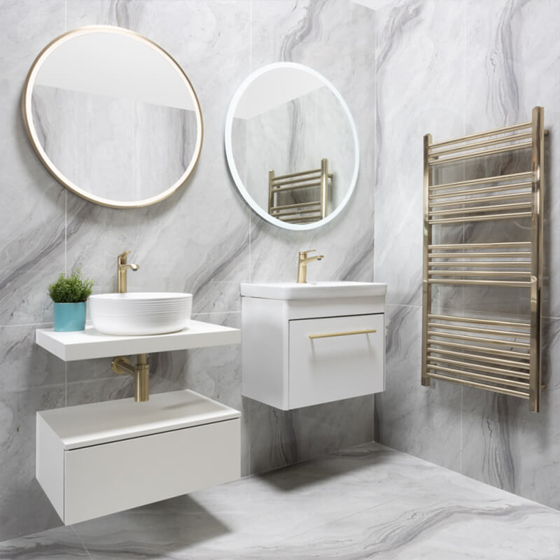 Marble-effect porcelain bathroom tiles Bathroom with large white marble-effect porcelain tiles on the walls and floor, round mirrors and a brass towel rail