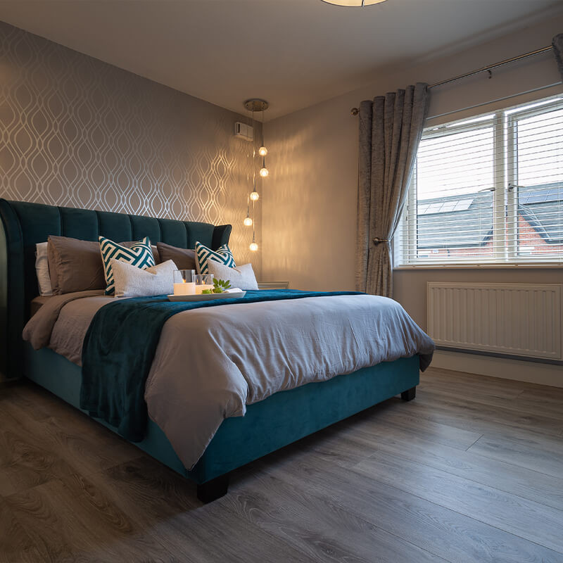 Modern bedroom with stylish grey laminate flooring instead of carpet.