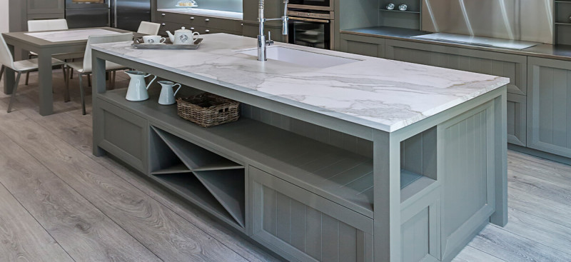 "Open-plan kitchen and dining area with grey stone-effect SPC flooring, highlighting the seamless transition and compatibility with underfloor heating systems.