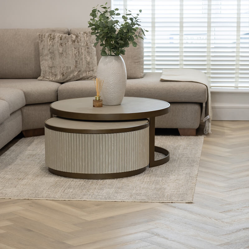 Modern SPC vinyl flooring in a contemporary living room with a beige sofa and round coffee tables